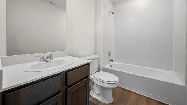a bathroom with a granite countertop sink toilet a mirror and shower