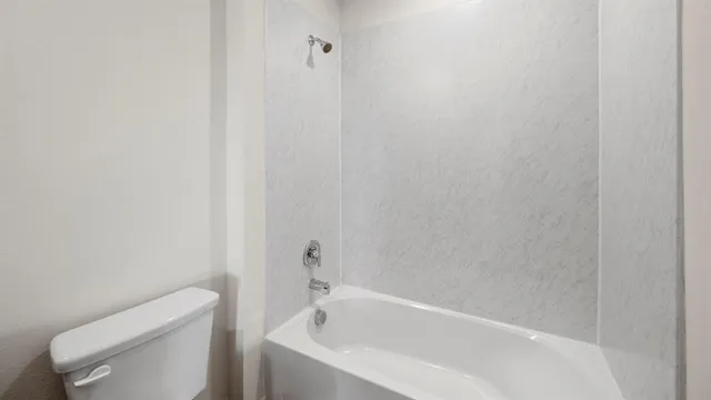 a white bath tub sitting next to a toilet