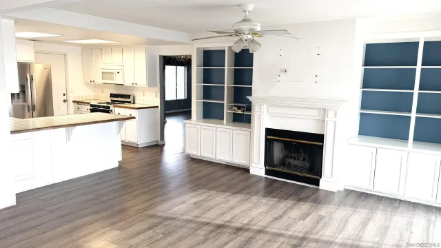 a view of a kitchen with cabinets and wooden floor