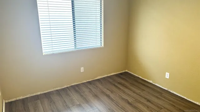 a view of a room that has a window and wooden floor