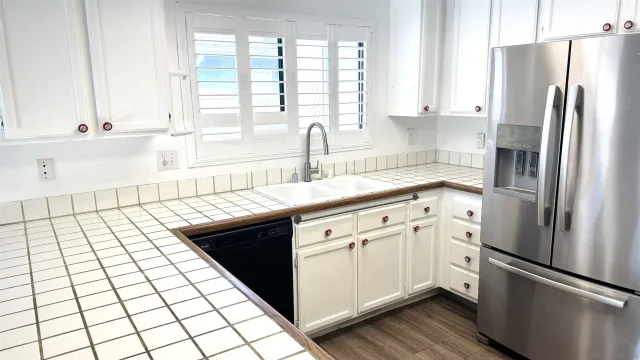 a kitchen with a refrigerator a sink and cabinets