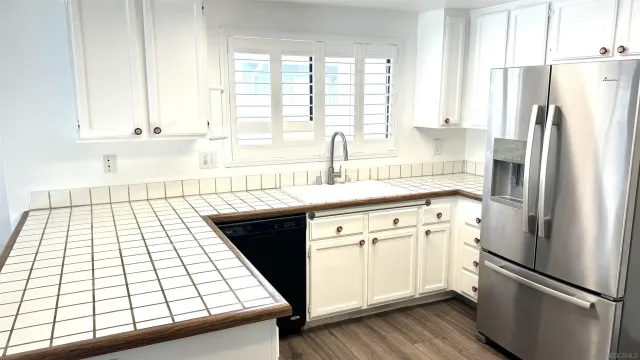 a kitchen with a refrigerator a stove sink and cabinets