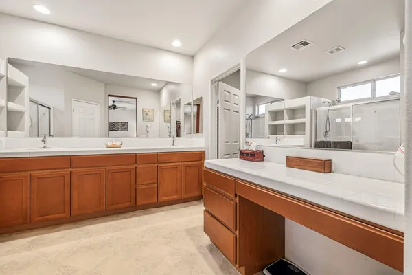 a spacious bathroom with a shower sink and mirror