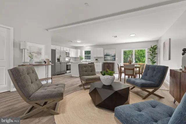 a living room with furniture and view of kitchen