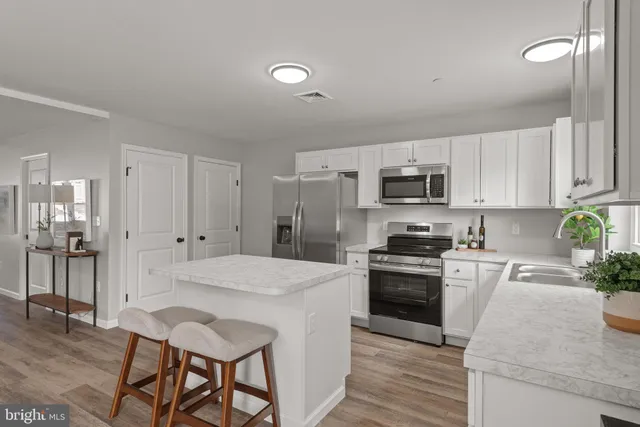 a kitchen with granite countertop a sink stove and refrigerator
