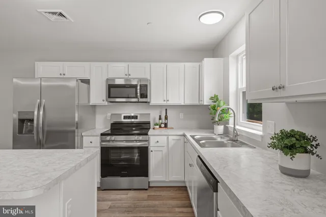 a kitchen with stainless steel appliances a sink stove and cabinets