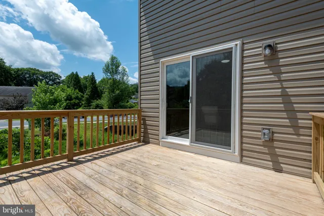 a view of a house with a deck and furniture