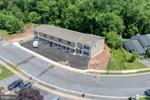 an aerial view of multiple houses with a yard
