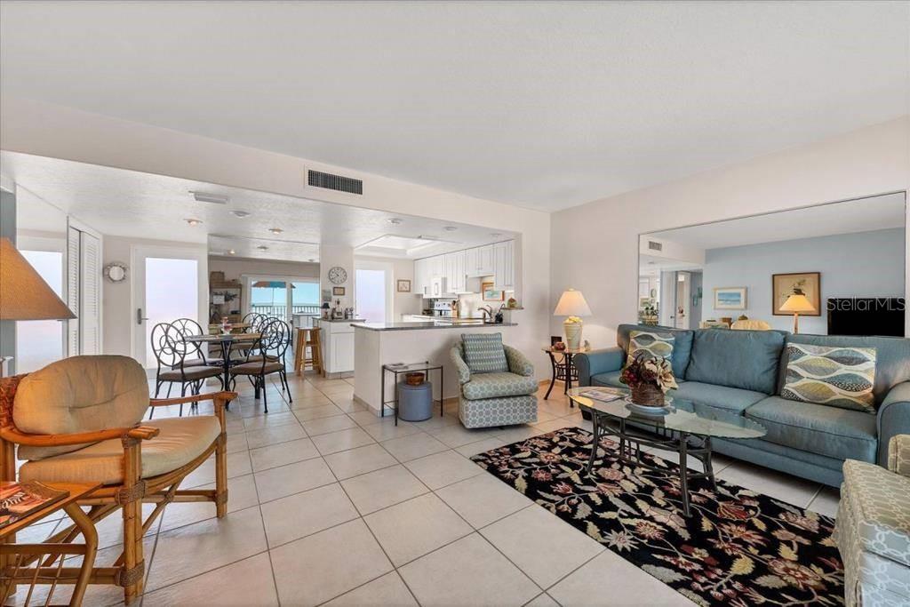 6154 Midnight Pass Road, Unit 305 Sarasota, FL 34242 - Photo 3 of 12 a living room with furniture and a dining table with chairs