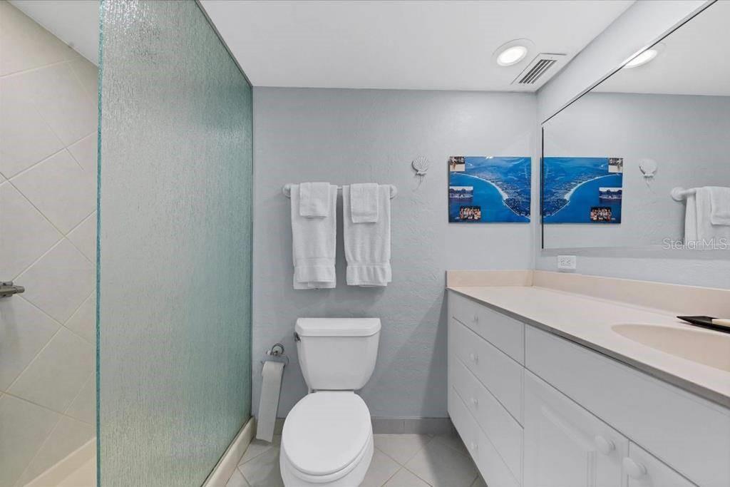 6154 Midnight Pass Road, Unit 305 Sarasota, FL 34242 - Photo 6 of 12 a bathroom with a toilet sink and mirror
