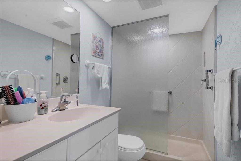 6154 Midnight Pass Road, Unit 305 Sarasota, FL 34242 - Photo 7 of 12 a bathroom with a sink toilet and shower