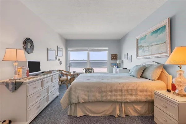 a bedroom with a bed and a flat tv screen on dresser