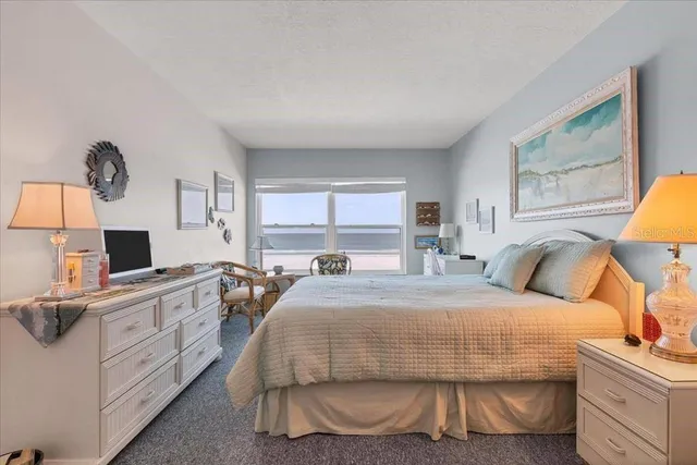 a bedroom with a bed and a flat tv screen on dresser