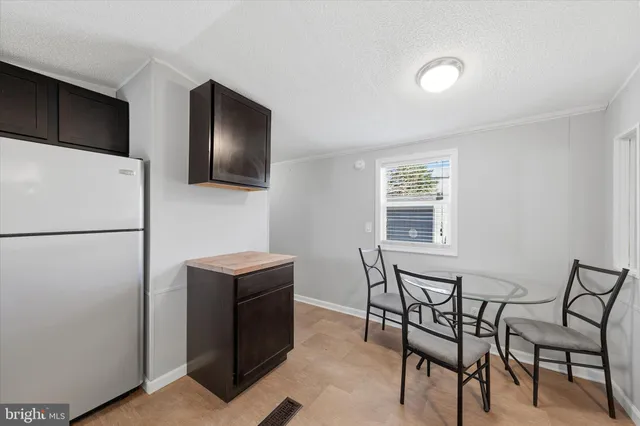 a kitchen with a refrigerator a table and chairs