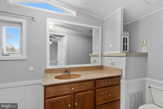 a bathroom with a sink vanity granite and toilet