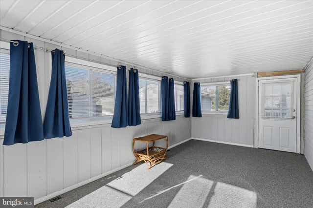 a living room with furniture and large windows