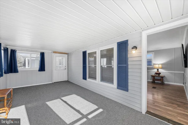 a view of a livingroom with wooden floor and furniture