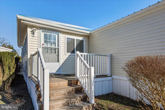 a view of a house with wooden deck and furniture