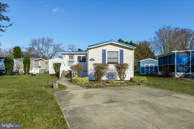 a front view of a house with a garden and trees