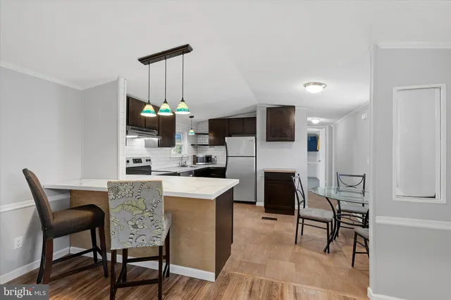 a dining room with kitchen island a dining table chairs with a stove and chairs