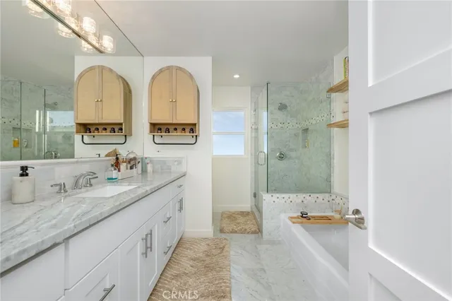 a spacious bathroom with a granite countertop tub sink a mirror a shower and vanity