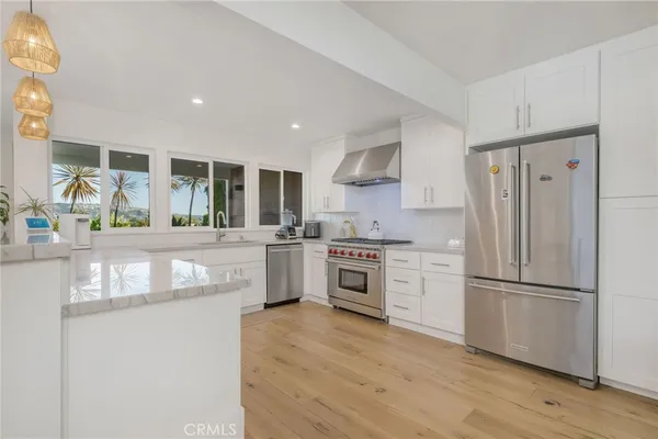 a kitchen with granite countertop a refrigerator stove top oven and sink