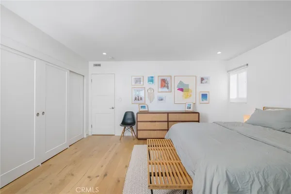a bedroom with a bed and glass walk in closet
