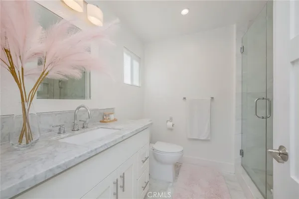 a bathroom with a granite countertop sink a toilet and a mirror