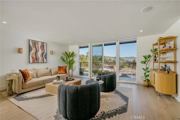 a living room with furniture potted plant and a large window