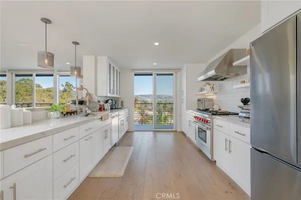 a large kitchen with white cabinets and stainless steel appliances