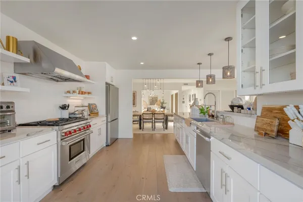 a kitchen with stainless steel appliances a stove a sink and white cabinets
