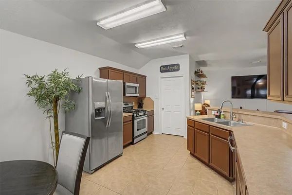 a kitchen with stainless steel appliances a sink stove refrigerator and cabinets