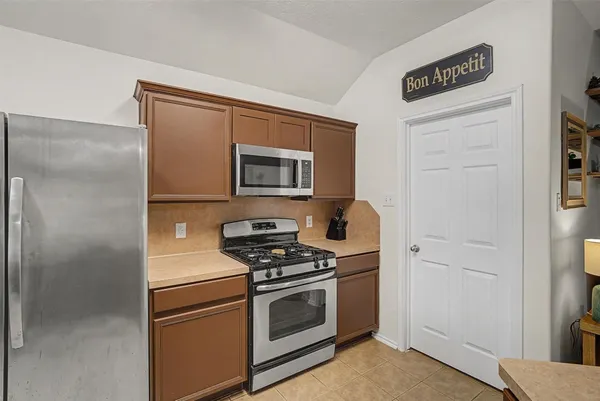 a kitchen with stainless steel appliances a refrigerator stove and microwave
