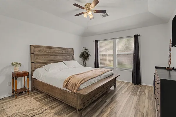 a bedroom with a bed lamp and a large window
