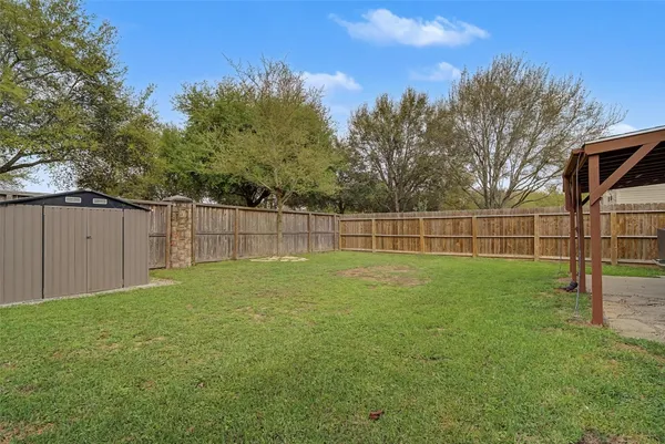 a view of a yard with a fence and trees
