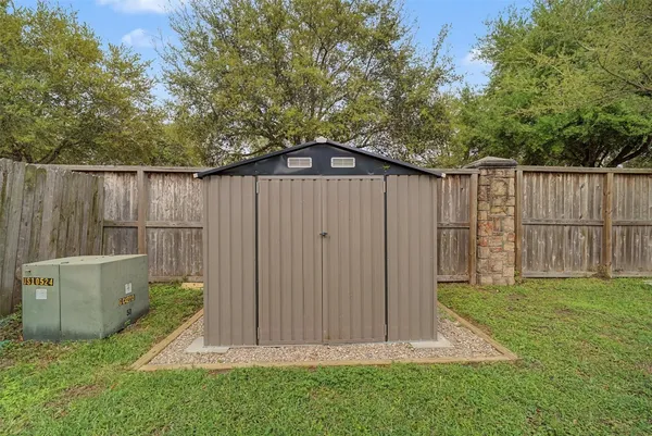 a view of a backyard with wooden fence and large trees