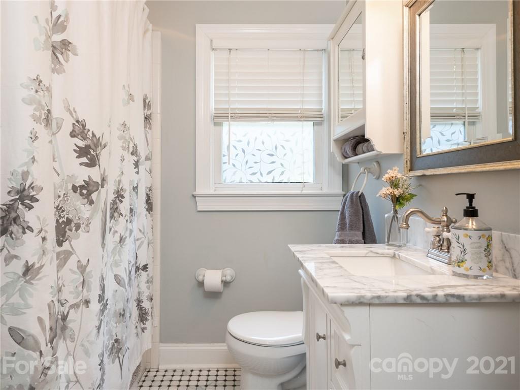 2012 Club Road Charlotte, NC 28205 - Photo 27 of 41 a bathroom with a granite countertop sink a toilet and a window
