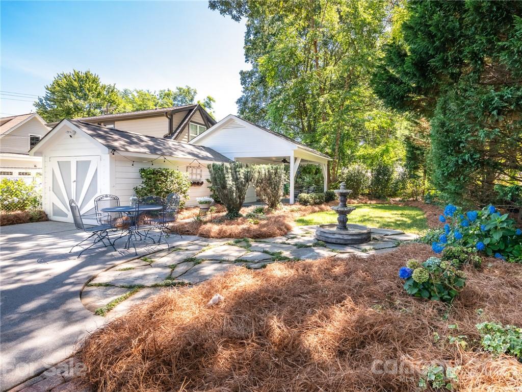2012 Club Road Charlotte, NC 28205 - Photo 39 of 41 a view of a patio with table and chairs under an umbrella with large trees