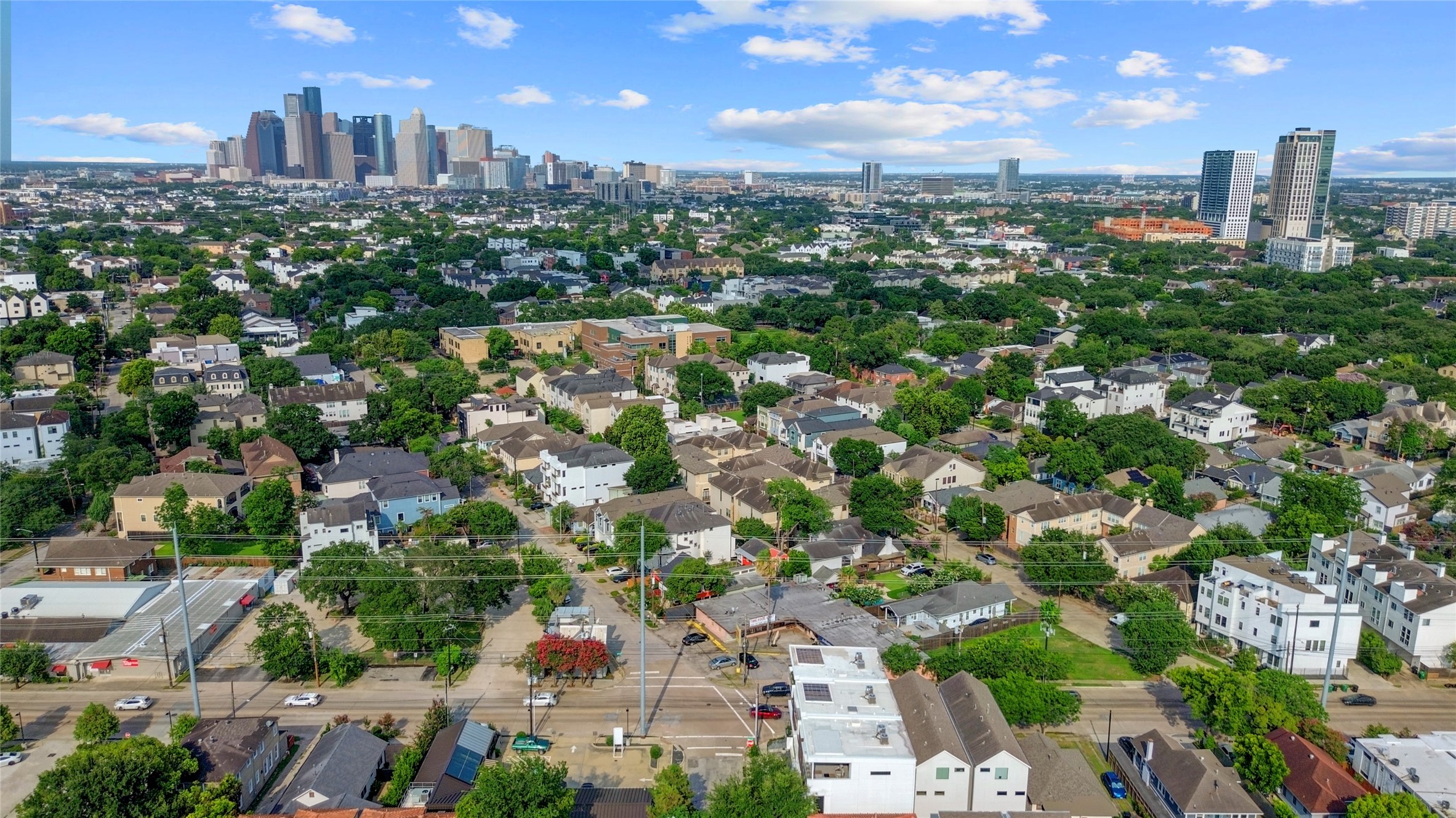 1807 Indiana Street Houston, TX 77006 - Photo 35 of 35 Aerial Skyline View: Spectacular drone overview highlighting the home's premier Montrose neighborhood location, showcasing its proximity to lush mature tree lines, vibrant urban hotspots, and a direct view of the Downtown Houston skyline.
