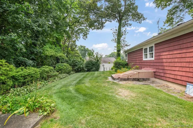 a view of a house with a yard and a tree
