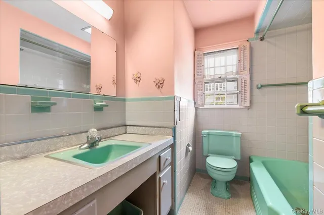 a bathroom with a granite countertop toilet sink and mirror