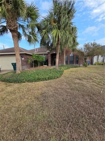 a front view of house with yard and trees