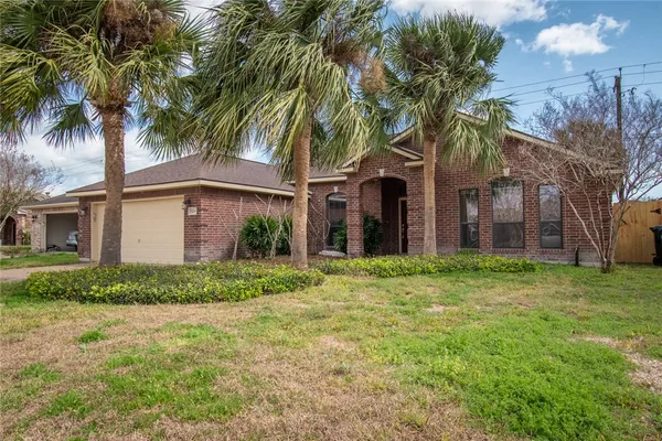 a view of a house with a yard and palm trees