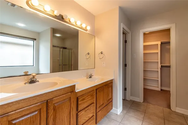 a spacious bathroom with a shower sink and mirror