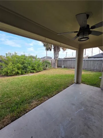 a view of an empty room with a chandelier fan