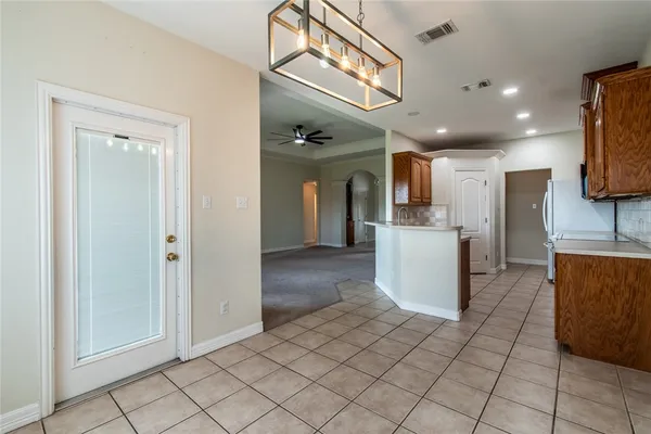 a view of a kitchen with furniture and a refrigerator