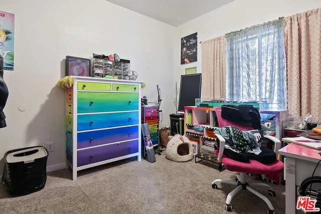 a view of a bedroom with workspace and windows