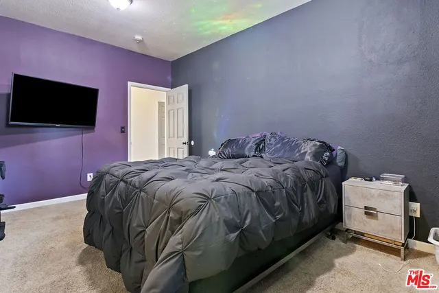 a bedroom with a bed and a flat screen tv