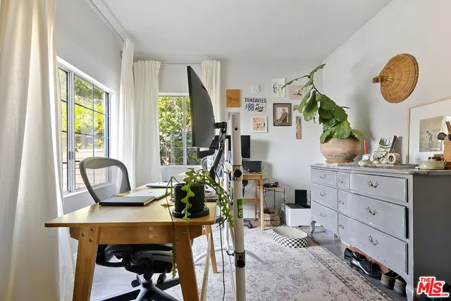 a view of a workspace with furniture and a window