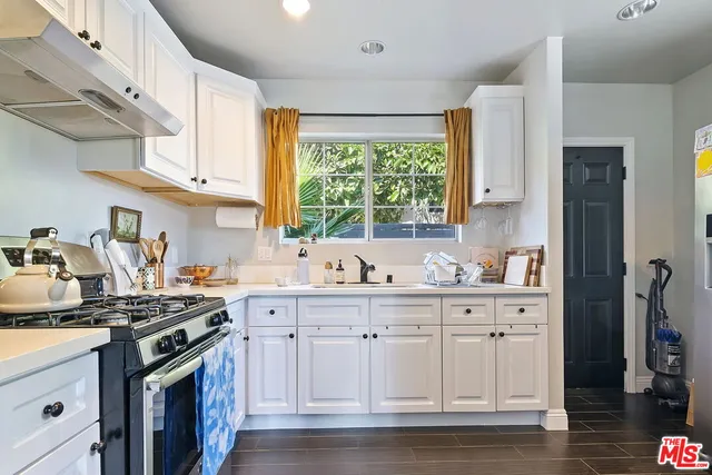 a kitchen with stainless steel appliances granite countertop a stove a sink and a refrigerator